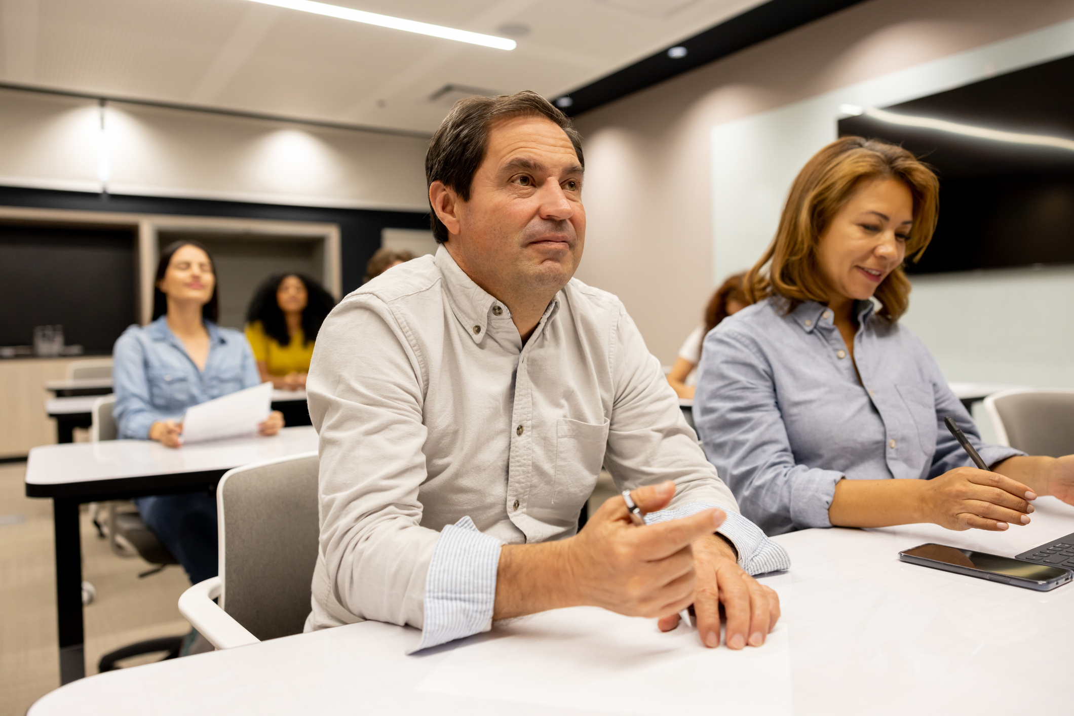 Latin American man paying attention while attending a business seminar - training concepts